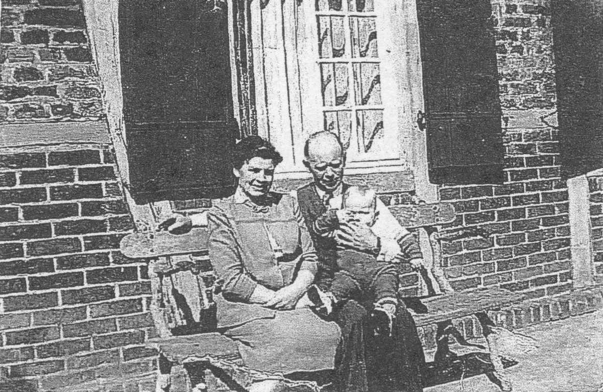 Paula Schipke sitzt gemeinsam mit ihrem Mann und ihrem ersten Sohn vor ihrem Haus.